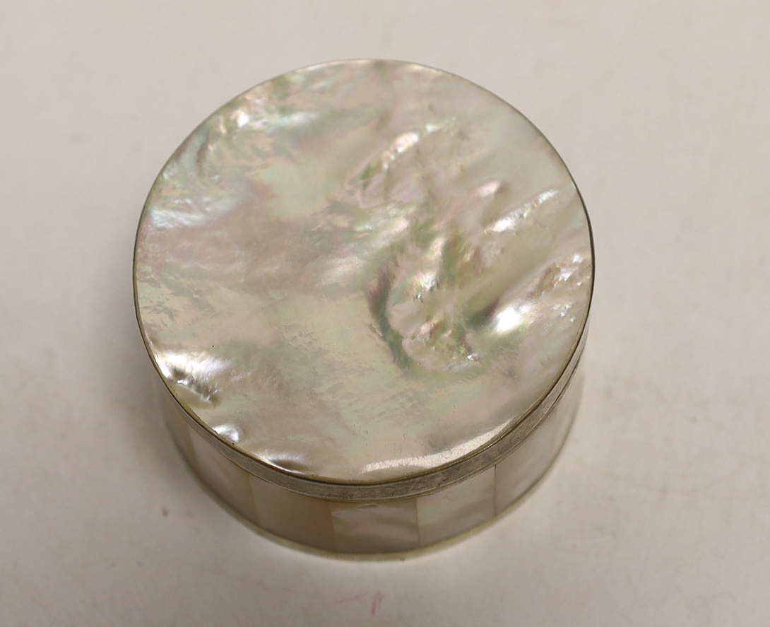 A white metal mounted mother of pearl circular box and cover, diameter 62mm.
